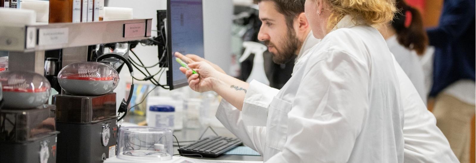 students in pharmacy practice lab looking at computer
